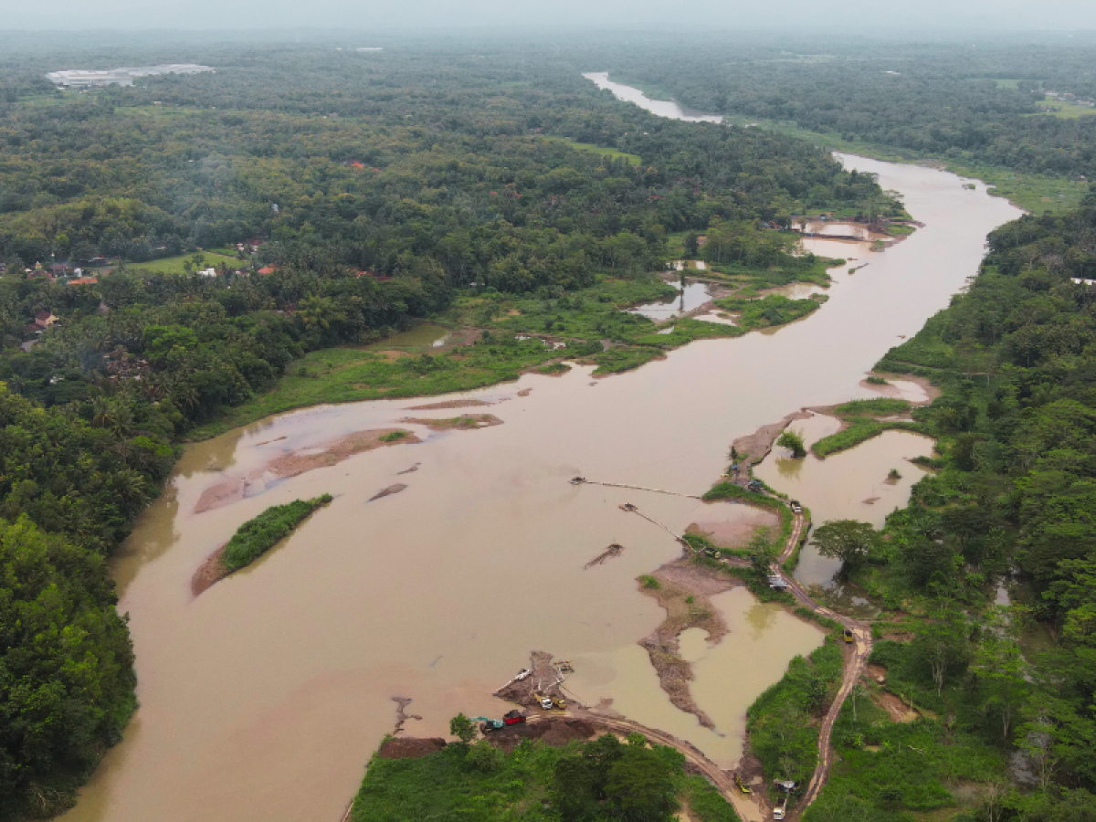 Airborne image of a river running through forested areas with structures